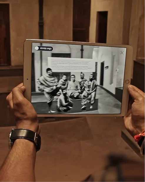 Visitor using a tablet with an archival image overlay in a museum