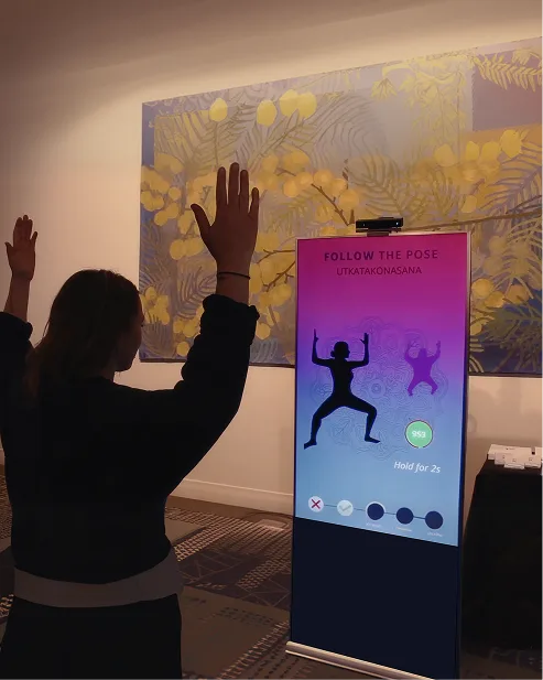 Person gesturing toward a vertical digital display