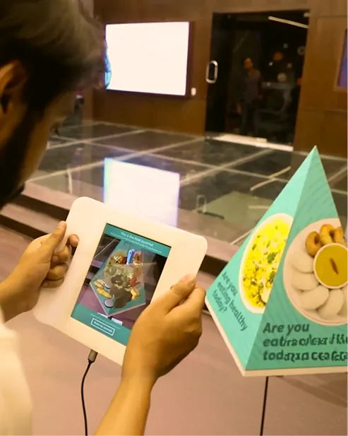 Hands holding a small screen near an exhibit